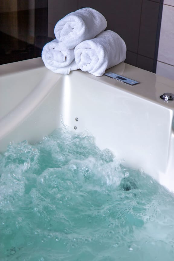 a bathtub full of water with towels on top of it