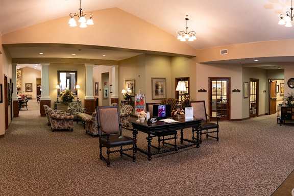 A large room with a table and chairs in the middle.