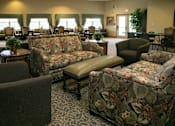 Thumbnail 2 of 11 - A living room with a couch, chair, and ottoman.
