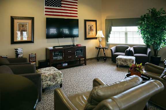A living room with a large leather chair and a television.