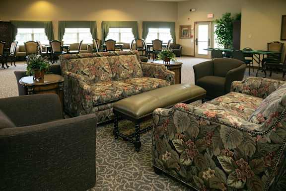 A living room with a couch, chair, and ottoman.