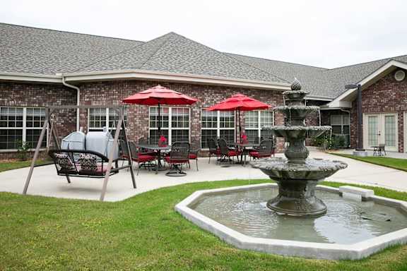 A patio with a table and chairs and a fountain.