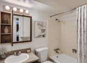 Thumbnail 7 of 20 - A bathroom with a white toilet, a white sink, and a white bathtub.