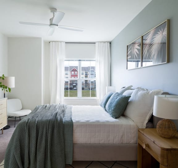 a bedroom with a bed and a large window