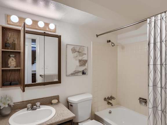 A bathroom with a white toilet, a white sink, and a white bathtub.