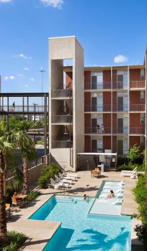 a view of a pool and a building with palm trees  at 1221 Broadway Lofts, San Antonio, TX