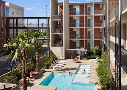 a view of a pool and a building with palm trees