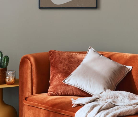 a couch with a pillow and a painting on the wall