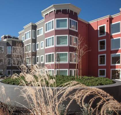 a row of apartment buildings with grass in the foreground