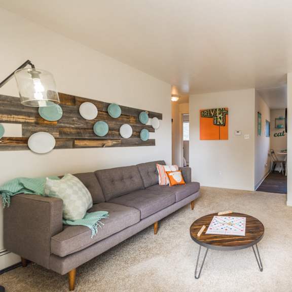 an open concept living room and dining area with a white dining table and rattan chairs