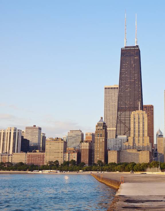 A city skyline with a body of water in the foreground.
