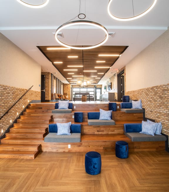 the lobby of a hotel with couches and a staircase at Lyric at Norton Commons Apartments, Prospect, Kentucky