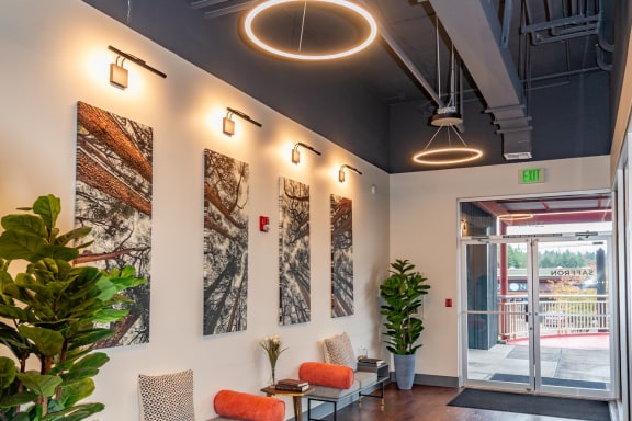 a lobby with chairs and plants and a glass door
