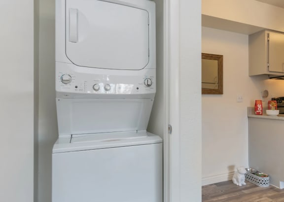 a white washer and dryer in a room next to a kitchen at Spring Meadow Aparmtents in Glendale, Arizona 85302
