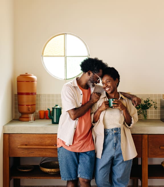 Man and Woman Smiling while Standing in Kitchen Together