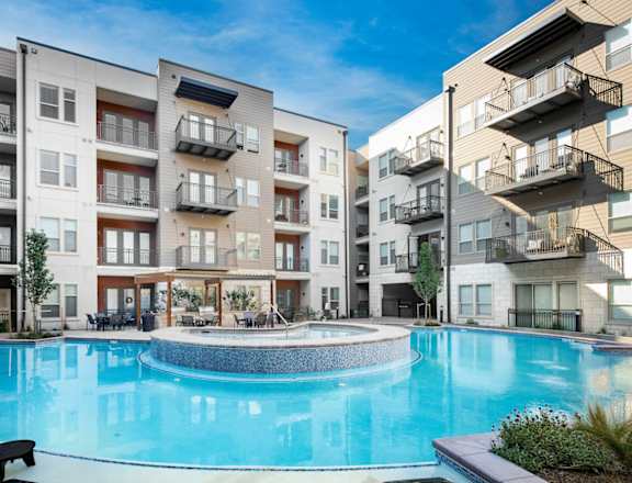 A swimming pool in front of apartment buildings at Bridges at Flatiron, Broomfield, 80021