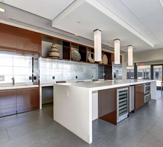 a large kitchen with a center island and a dining area in the background