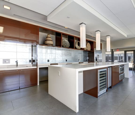 a large kitchen with a center island and a dining area in the background