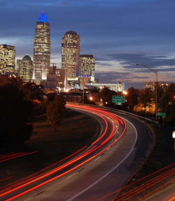 A long exposure shot of a highway with light trails from the moving vehicles.