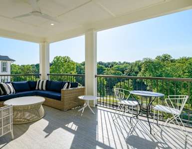 a covered porch with furniture and a table and chairs at The Eddy at Riverview, Smyrna