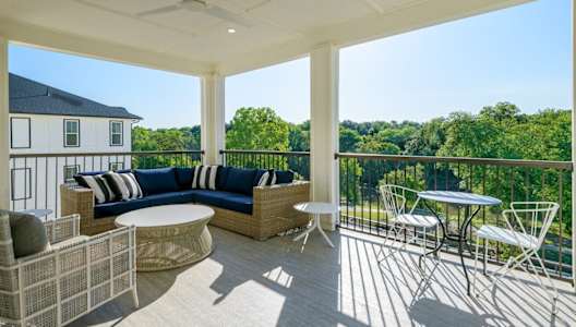 a covered porch with furniture and a table and chairs at The Eddy at Riverview, Smyrna