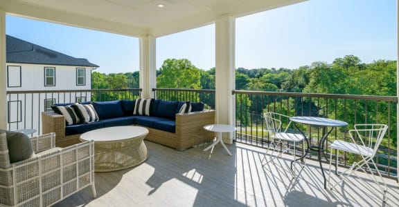 a covered porch with furniture and a table and chairs at The Eddy at Riverview, Smyrna