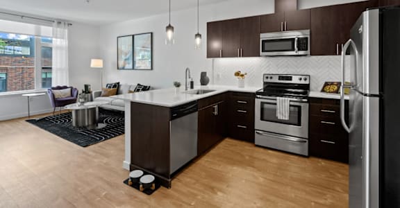 full kitchen with stainless steel appliances and white countertops in an apartment at The Parker in Portland, OR