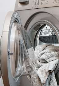 A washing machine with a grey towel in the drum.