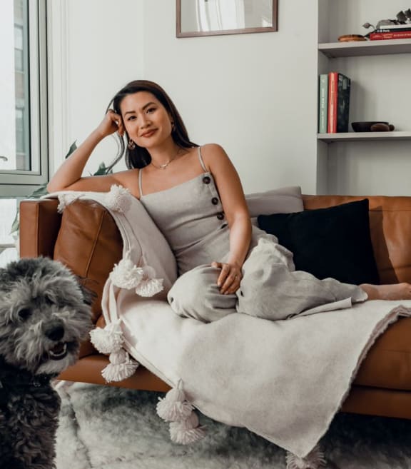 a woman sitting on a couch with her dog
