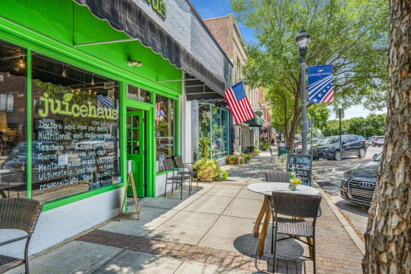 Outside of Juice Hause's store front with a set of table with two chairs