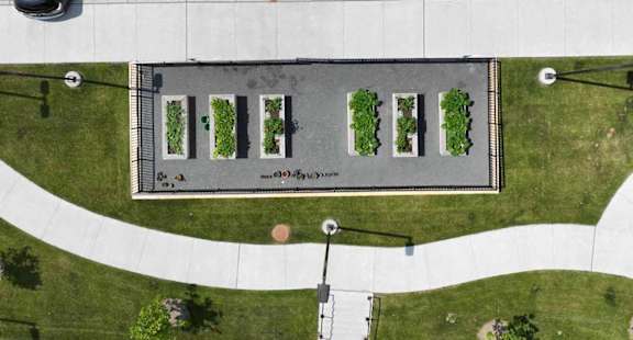 an aerial view of a building with trees on the sidewalk