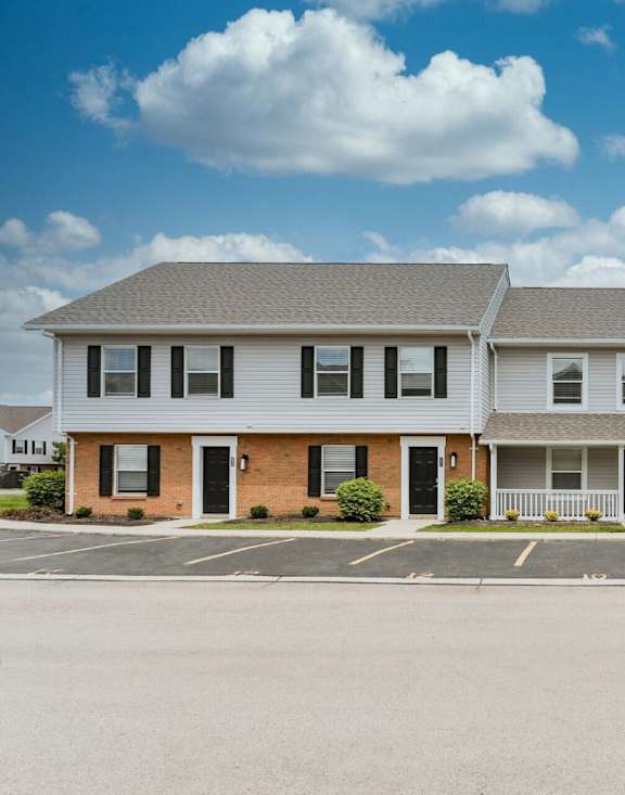 A two-story building with a parking lot in front.