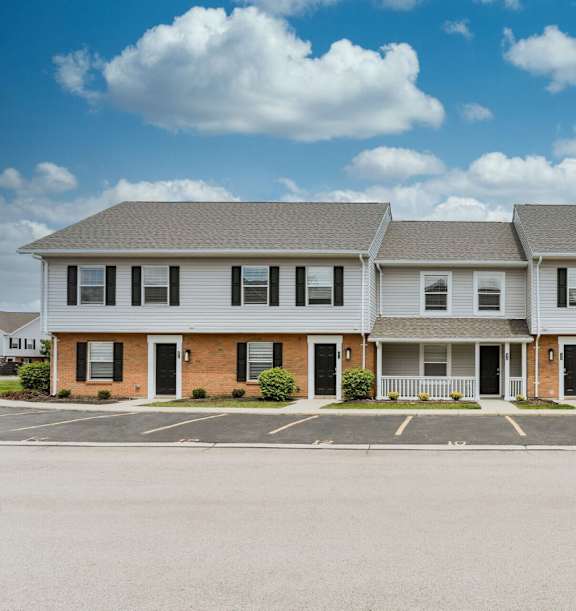 A two-story building with a parking lot in front.