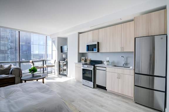 A modern kitchen with a refrigerator, oven, and microwave.