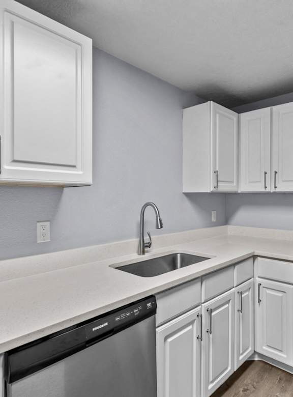 A kitchen with white cabinets and appliances.