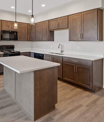 A modern kitchen with wooden cabinets and a white countertop.