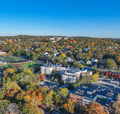 A view of a town with buildings and trees in autumn colors.