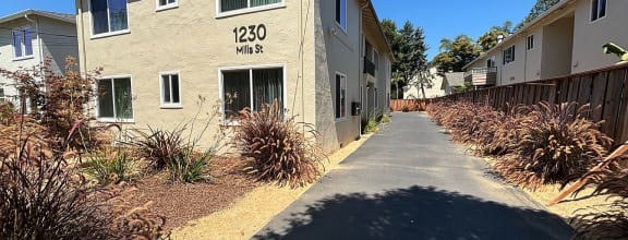 an apartment building with a sidewalk in front of it