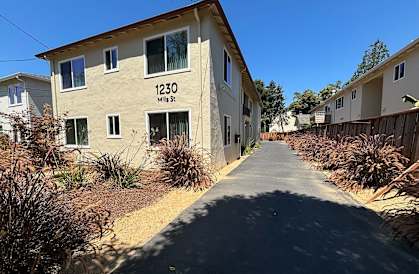 an apartment building with a sidewalk in front of it