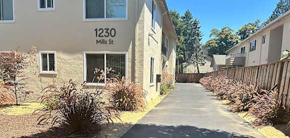 a sidewalk in front of an apartment building
