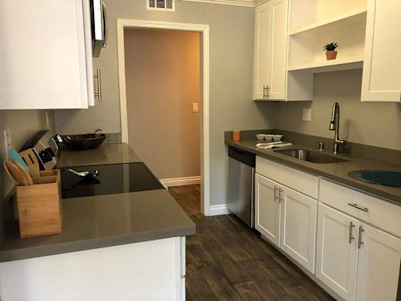 A kitchen with white appliances and cabinets.