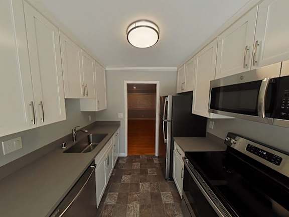 A kitchen with black appliances and white cabinets.