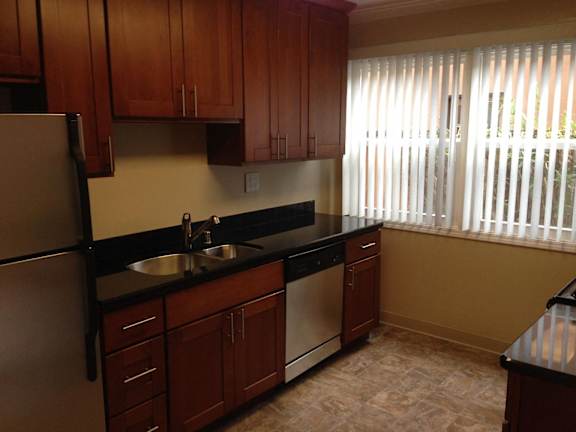 A kitchen with wooden cabinets and a black countertop.