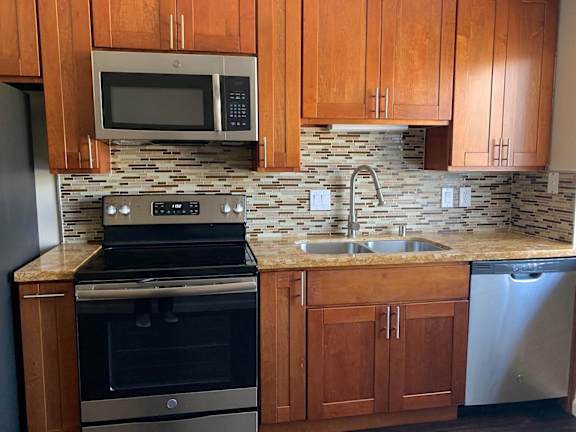 a kitchen with stainless steel appliances and wooden cabinets