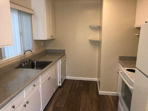 A kitchen with white cabinets and a granite countertop.