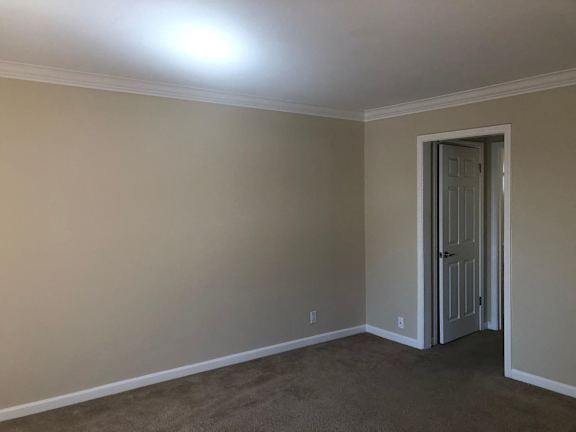 A room with wooden floors and a window with blinds.