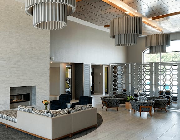 a large lobby with a couch and chairs and a fireplace at Gabella at Parkside, Minnesota, 55124