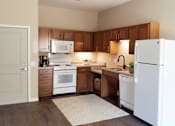 Thumbnail 17 of 19 - A kitchen with white appliances and wooden cabinets.