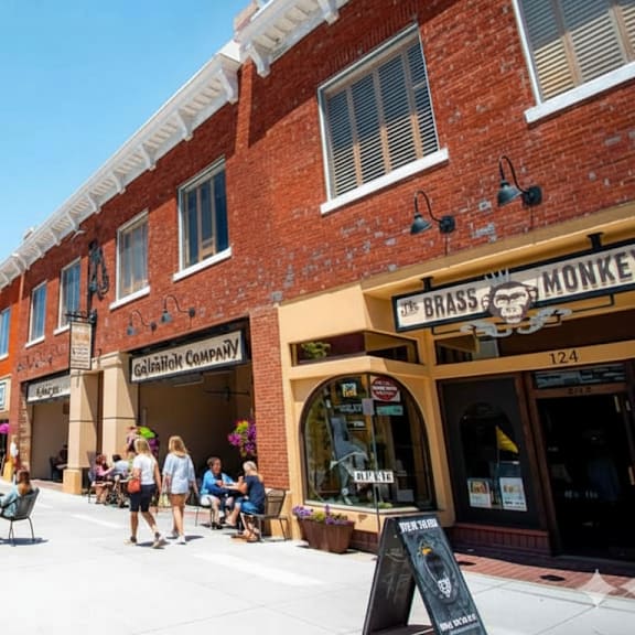 A street view of a town with people sitting outside a restaurant.