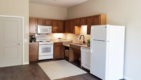 A kitchen with white appliances and wooden cabinets.